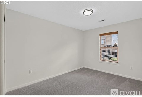 A room with a window and carpeted floor.