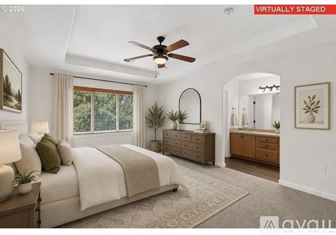 A bedroom with a large bed, a ceiling fan, and a window with blinds.
