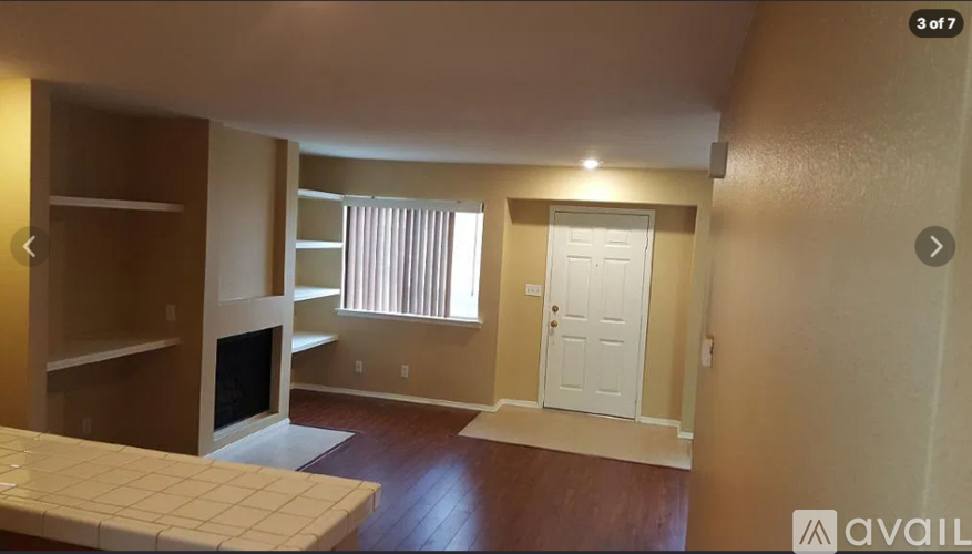A living room with a fireplace and a door to the right.