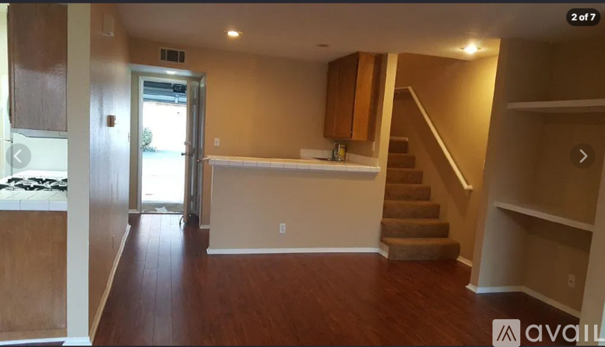 A room with wooden floors and a staircase leading to another level.