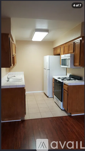 A kitchen with white appliances and wooden cabinets.