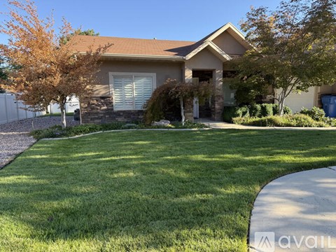 A house with a brown roof and a white fence is for sale.