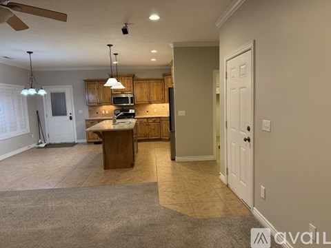 A kitchen with a white door and a brown table.