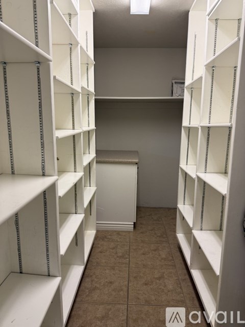 Empty white shelves in a storage room.