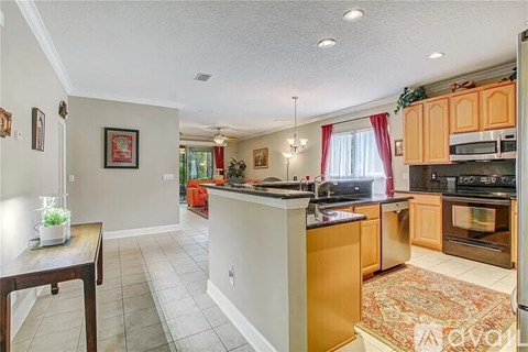 A kitchen with wooden cabinets and a tiled floor.
