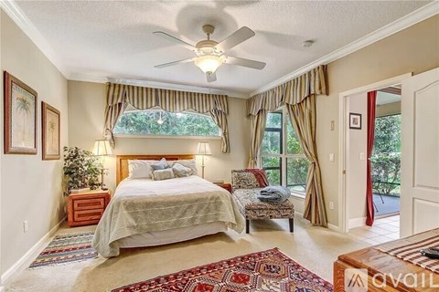 A bedroom with a large bed and a ceiling fan.