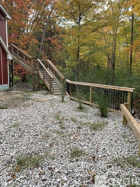 A wooden staircase with a railing leads up to a building.