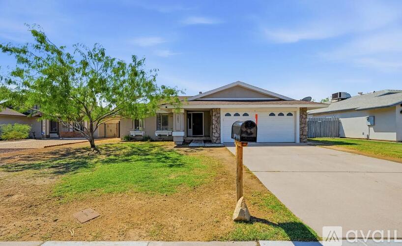 A house with a brown roof and a white fence is for sale.