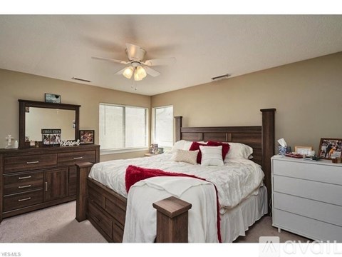 A bedroom with a large bed, a dresser, and a mirror.
