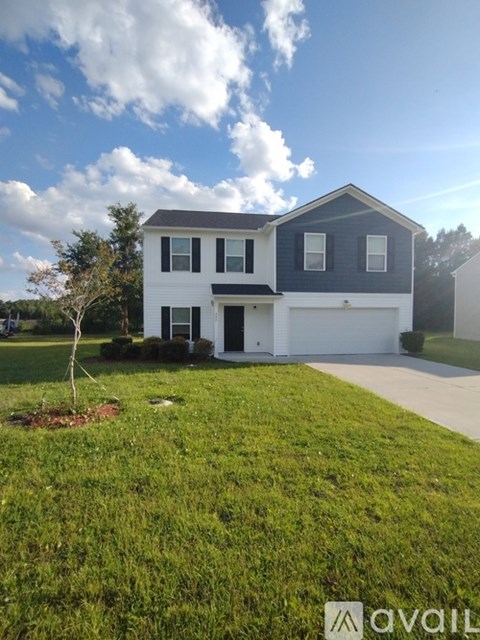 A two-story house with a white garage door and a black roof.