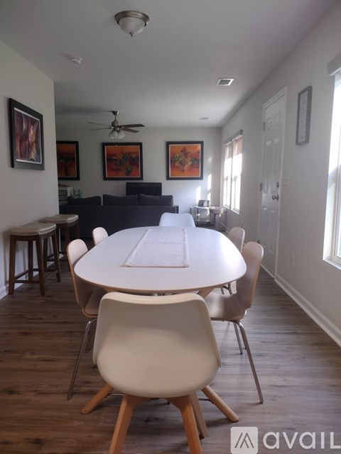 A dining room with a white table and chairs.