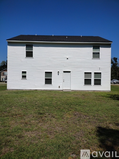 A white house with a black roof and a white door.