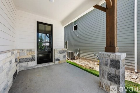 A house with a stone pillar and a black door.
