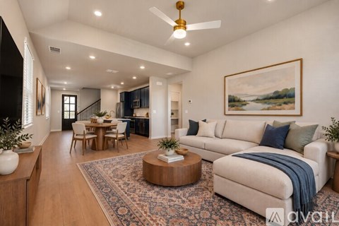 A living room with a white couch and a painting on the wall.