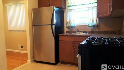 A kitchen with a stainless steel refrigerator and a black stove top.
