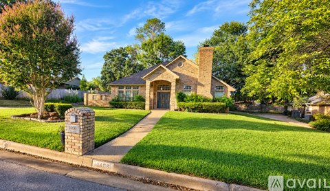 A house with a well-maintained lawn and a brick chimney is for sale.