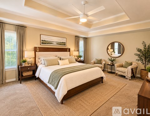 A bedroom with a large bed and a ceiling fan.