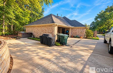 A house with a black lawn chair and a green trash can in front of it.