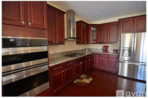 A kitchen with wooden cabinets and a granite countertop.