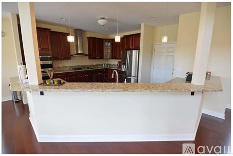 A kitchen with brown cabinets and a granite countertop.