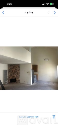A room with a stone fireplace and a wooden cabinet.