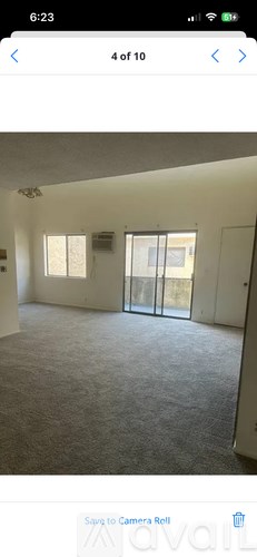 A room with a carpeted floor and a sliding glass door.