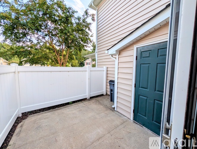 A white fence and a green door are visible in the image.