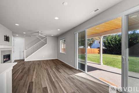 A spacious living room with a staircase and a fireplace.