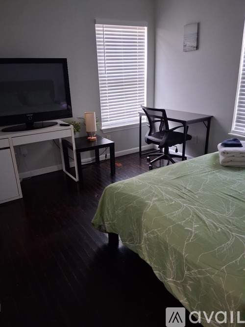 A bedroom with a bed, desk, and chair.