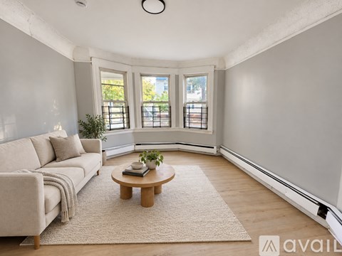 A living room with a couch, a coffee table, and a rug.