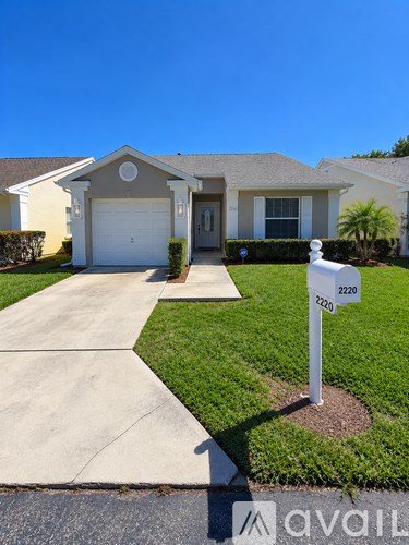 A house with a driveway and a mailbox with the number 2220 on it.