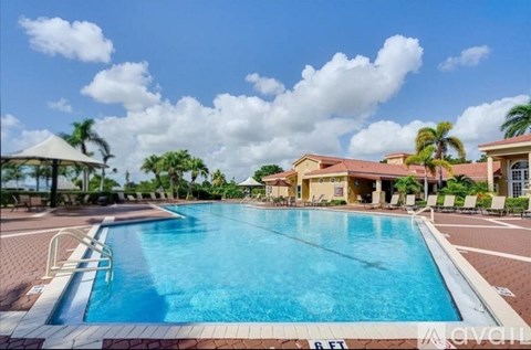 A large swimming pool in front of a building with a gazebo in the background.