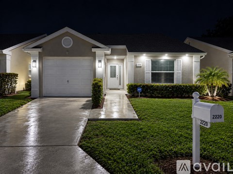 A house with a driveway and a mailbox with the number 2220 on it.