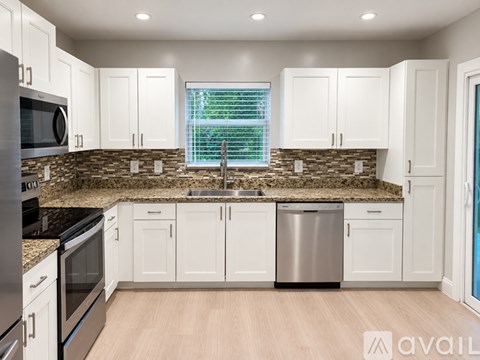 A kitchen with white cabinets and a granite countertop.