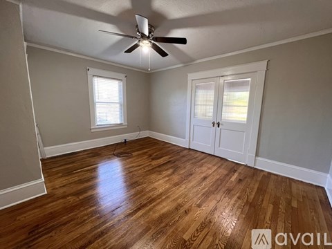 A room with wooden flooring and a ceiling fan.
