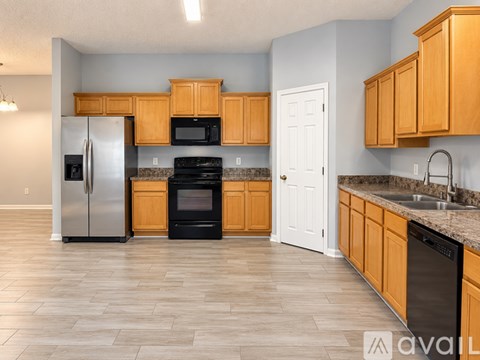 A kitchen with wooden cabinets and a black oven.