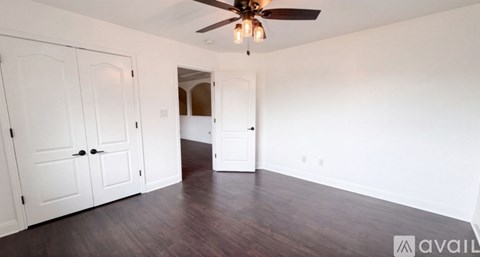 A room with a ceiling fan and two white doors.