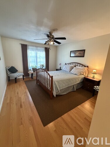 A bedroom with a large bed and a ceiling fan.