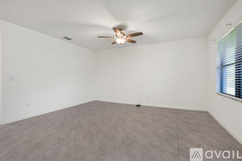 A spacious room with a ceiling fan and carpeted floor.