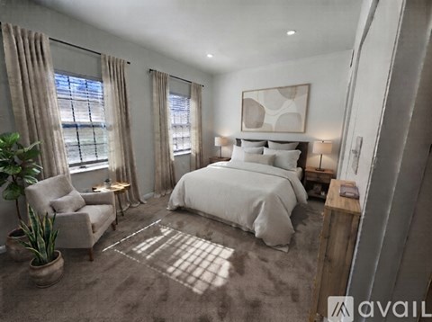 A bedroom with a large bed, a chair, and a potted plant.