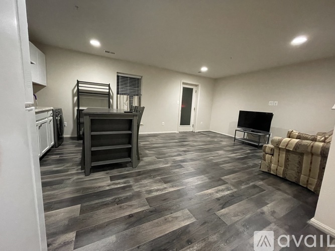 A living room with a grey sofa and a television set.