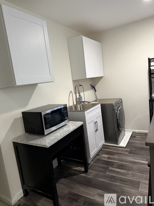A kitchen with a black microwave on a countertop.