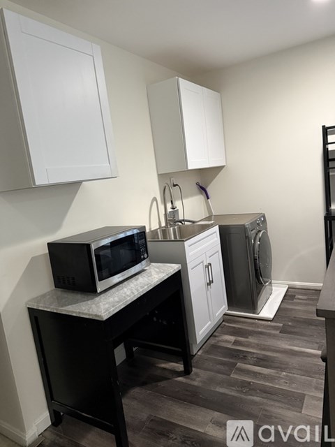 A kitchen with a black microwave on a countertop.