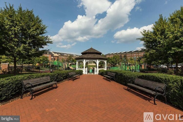 A park with a gazebo surrounded by benches and trees.
