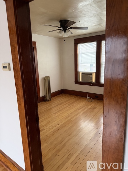 A room with wooden floors and a ceiling fan.