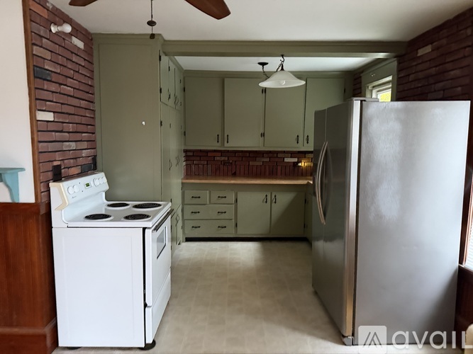 A kitchen with a white stove and a white refrigerator.