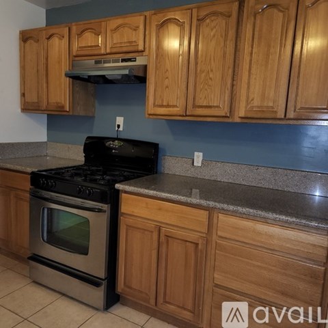 A kitchen with wooden cabinets and a black stove top oven.