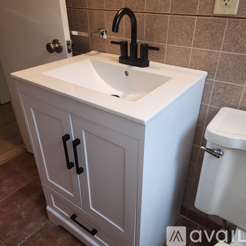 A white sink is on top of a cabinet in a bathroom.