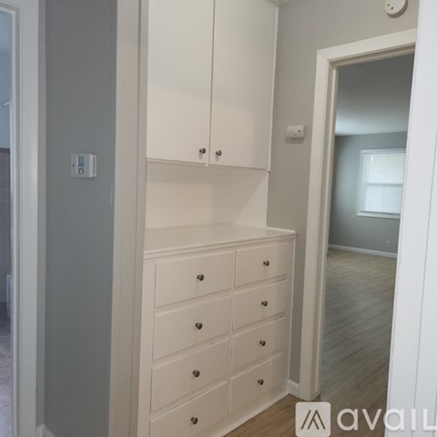 A white dresser with a mirror above it.