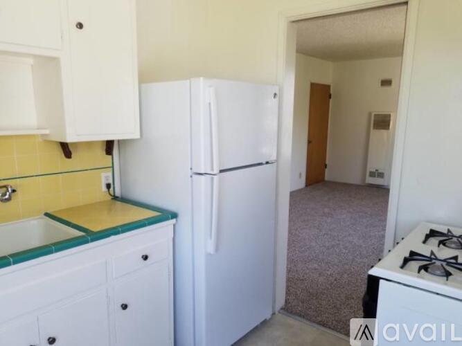A kitchen with a white fridge and a white stove.